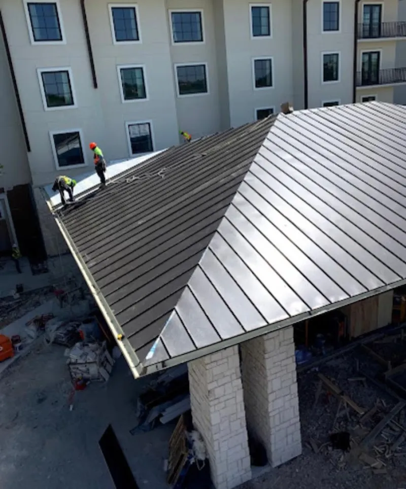 Crew installing standing seam metal roof panels on a commercial project in Miami Shores